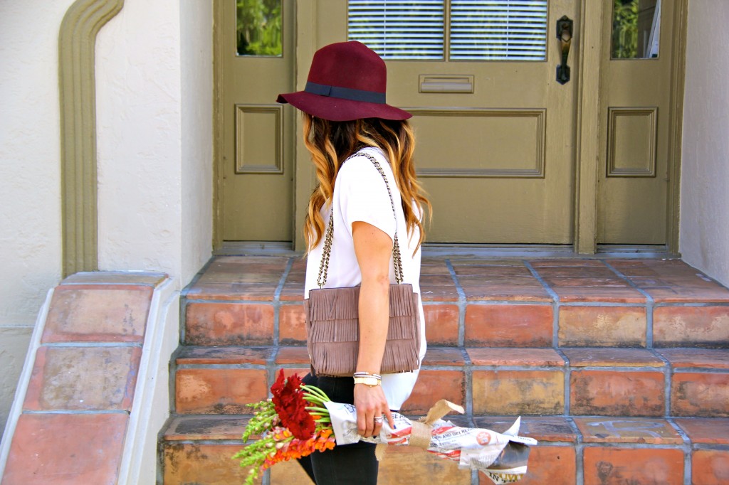 maroon fedora, white blouse, fringe purse