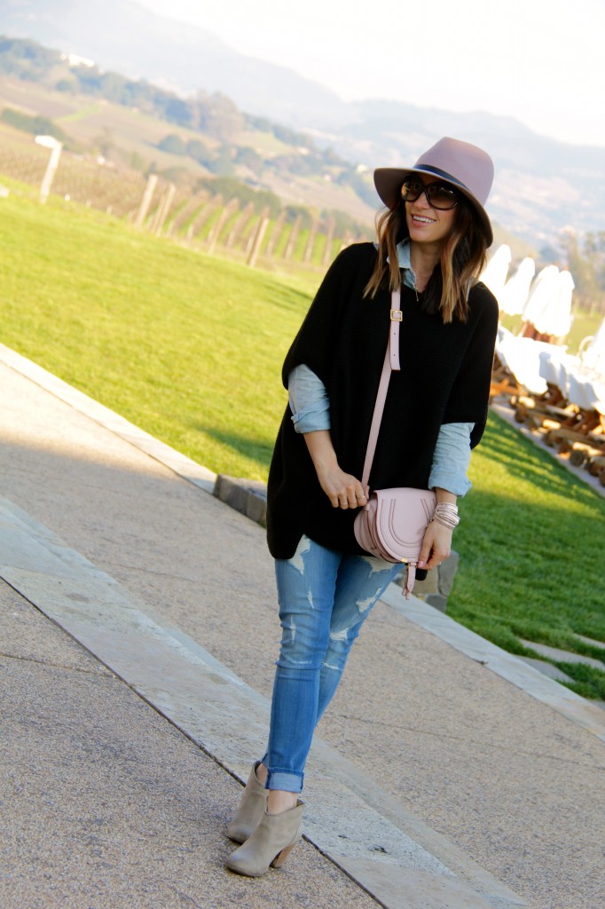 distressed denim, pink fedora, black poncho 